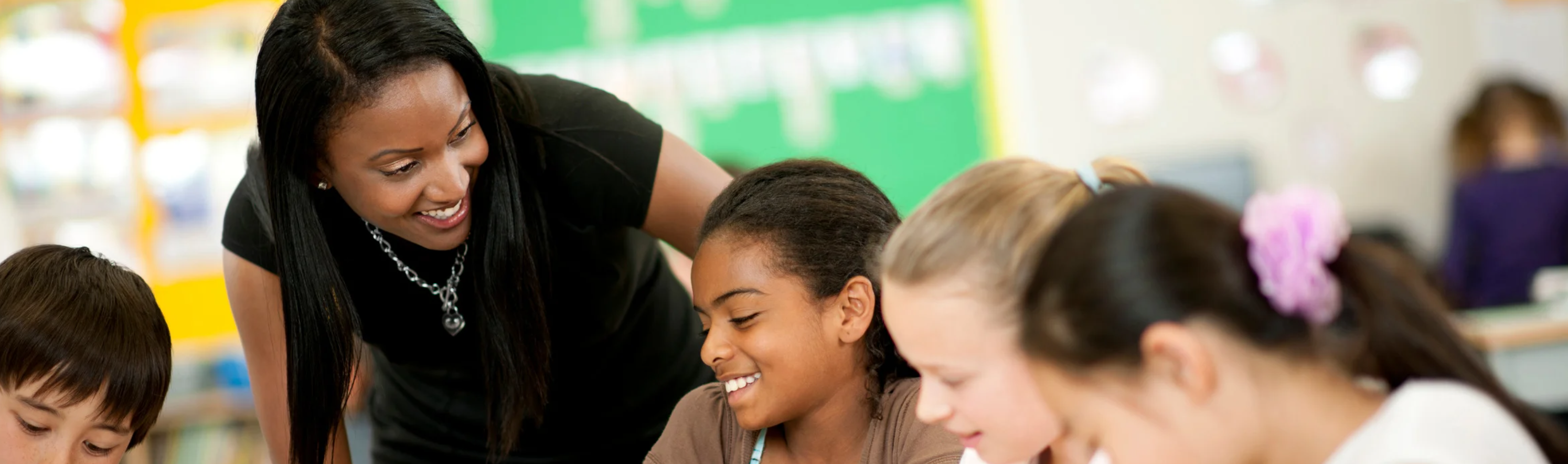 teacher helping students in a classroom setting