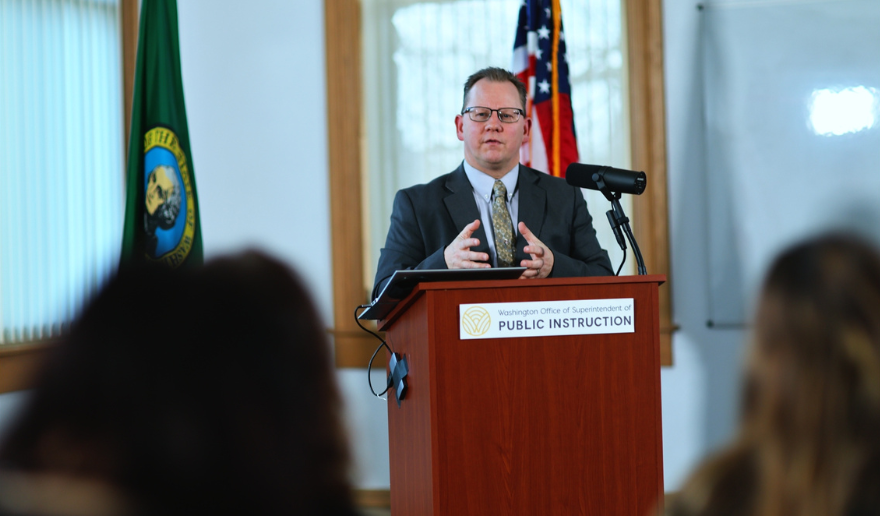 Superintendent Reykdal behind a podium