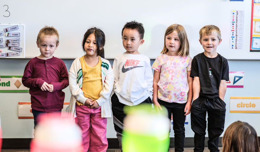 school children standing in front of a class