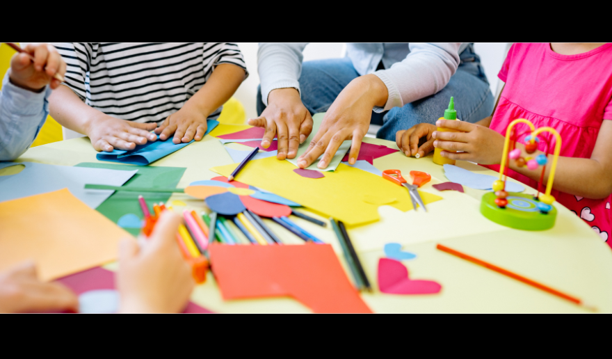 Young students gathered around a table working on projects together.