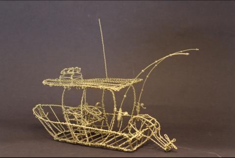 A wire sculpture of a boat, intricately crafted with detailed elements such as the hull, deck, and fishing rods.