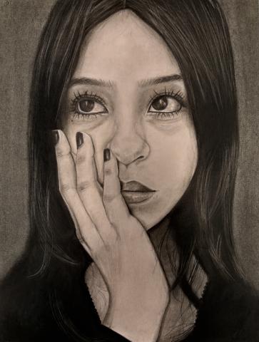 The image shows a portrait of an individual in thought with long, dark hair against a neutral background