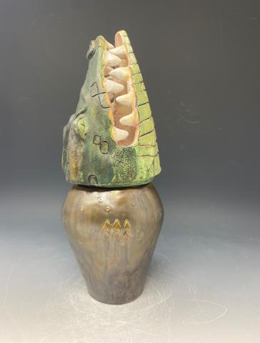 An Egyptian clay canopic jar in the shape of a crocodile