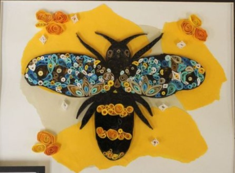 A 3D paper quilling collage of a bumble bee with colorful wings.