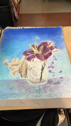 Purple and light brown flowers in jar with falling petals . Background is shaded with blue and the jar rests on a light reflective gradient counter.