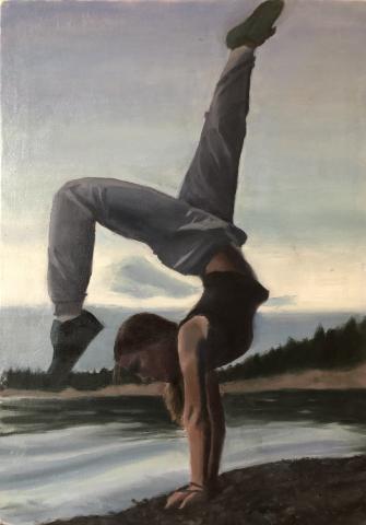 This image shows a shadowy girl in a creative handstand pose, set against the cool-toned landscape of a beach reflecting a vibrant blue sky and forested horizon.