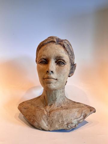 Unglazed ceramic sculpture of a woman bust with surface texture