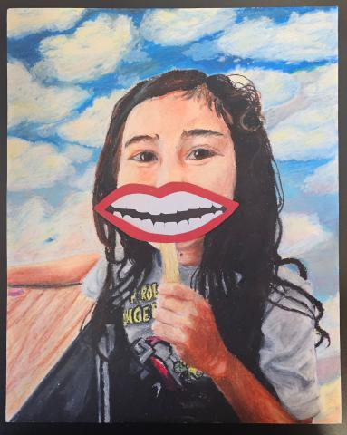 "One, Two, Three, Cheese!" is an oil pastel artwork depicting myself as a little girl, around age 5, holding a handmade paper smile on a popsicle stick over my true smile. I have dark tousled wavy hair, a grey power rangers t-shirt, and brown dark brown eyes. I sit at a wooden school classroom desk, but behind me is an entirely surreal cloud setting. I used real construction paper to create the smile: maroon red lips, crooked off-white teeth, and a black for the mouth's interior. The paper pops out on top o