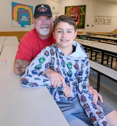 Larry Smith poses for a photo with his son in the Littlerock cafeteria.
