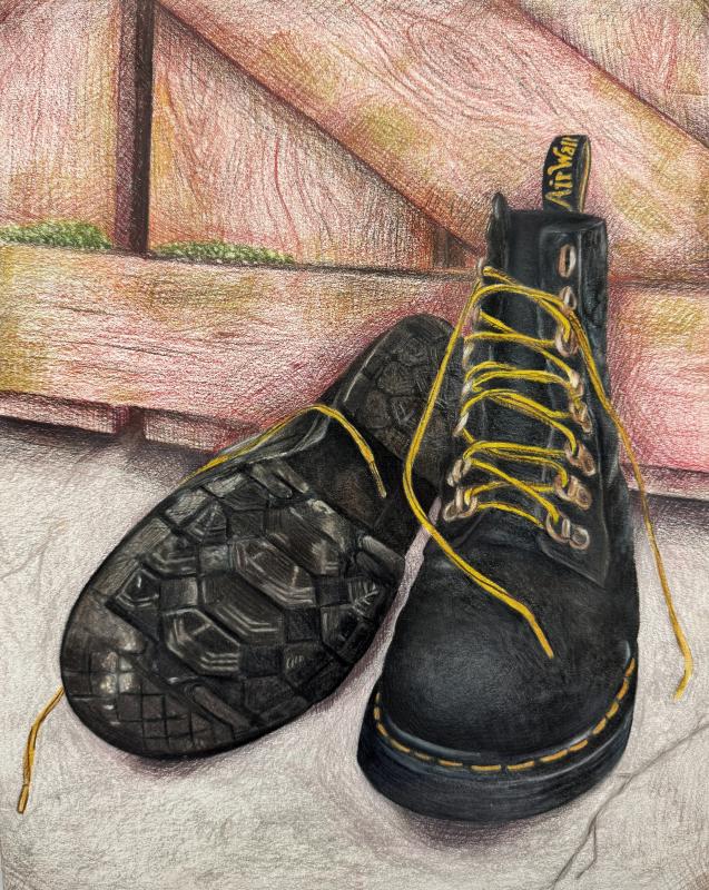 A pair of black boots with yellow laces. One boot is standing upright while the other is lying on its side, displaying the sole with a rugged tread pattern.