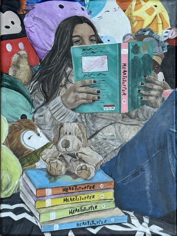 The artwork depicts a person with long dark hair sitting on a bed or couch, surrounded by various plush toys. The person is reading a book titled "Heartstopper" and has several other books from the same series stacked nearby.