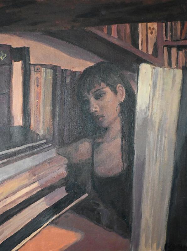  a person in what appears to be a library or study room. The person's face is partially obscured by a large book in the foreground
