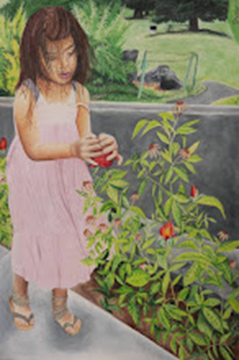 A young child in a pink dress standing on a concrete path next to a garden bed with green plants and red flowers. The child is holding one of the flowers and appears to be examining it closely