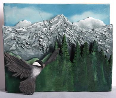 A clay/ceramics image of a northwest mountain scene with a chickadee flying in it.