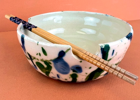 A ceramic bowl with abstract blue and green to represent colors in the PNW. There is a notch for where the chopsticks go. 
