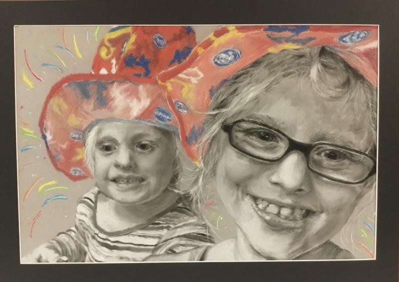 Black-and-white portrait of two smiling children wearing brightly colored, whimsical circus hats; vivid reds, yellows, and blues contrast with grayscale faces, creating a playful, joyful, and nostalgic atmosphere.