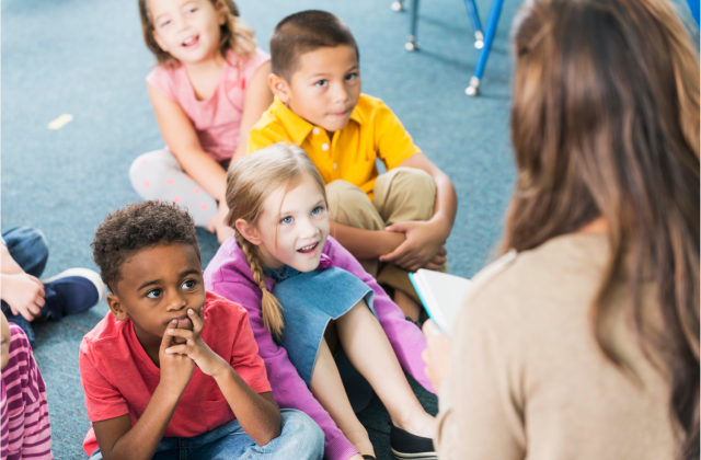 Kindergarteners listen to a teacher reading