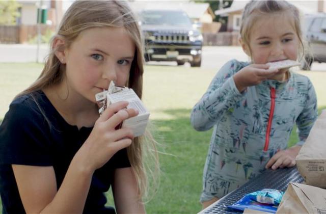 Two kids drinking milk and eating food.