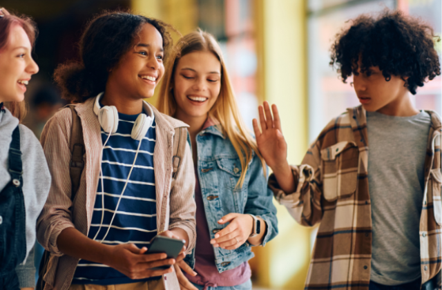 A group of students talking to each other in the hallway.