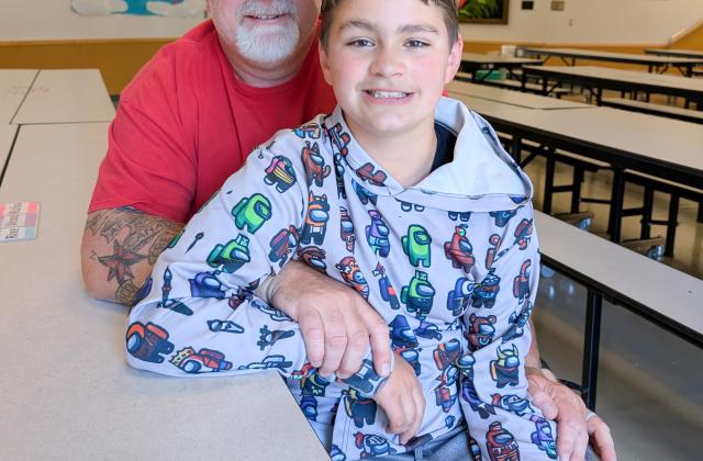 Larry Smith poses for a photo with his son in the Littlerock cafeteria.