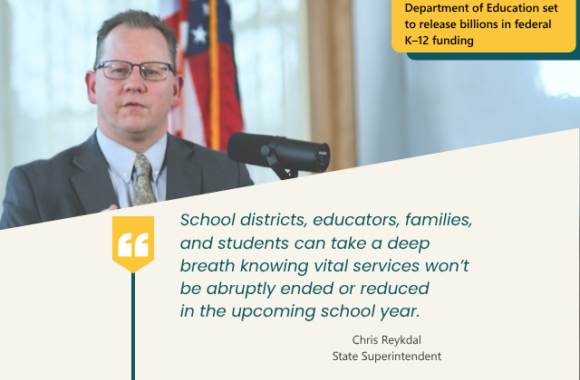 Superintendent speaking at podium with text below