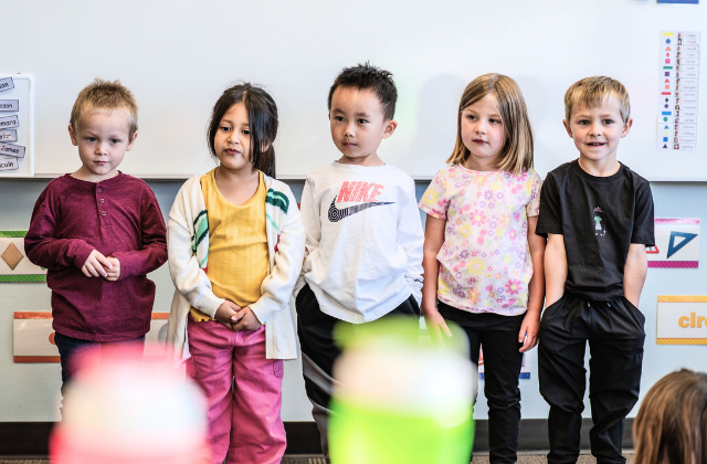 Kids in school standing in front of the class