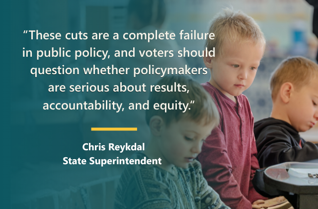 Children looking down at a desk in school